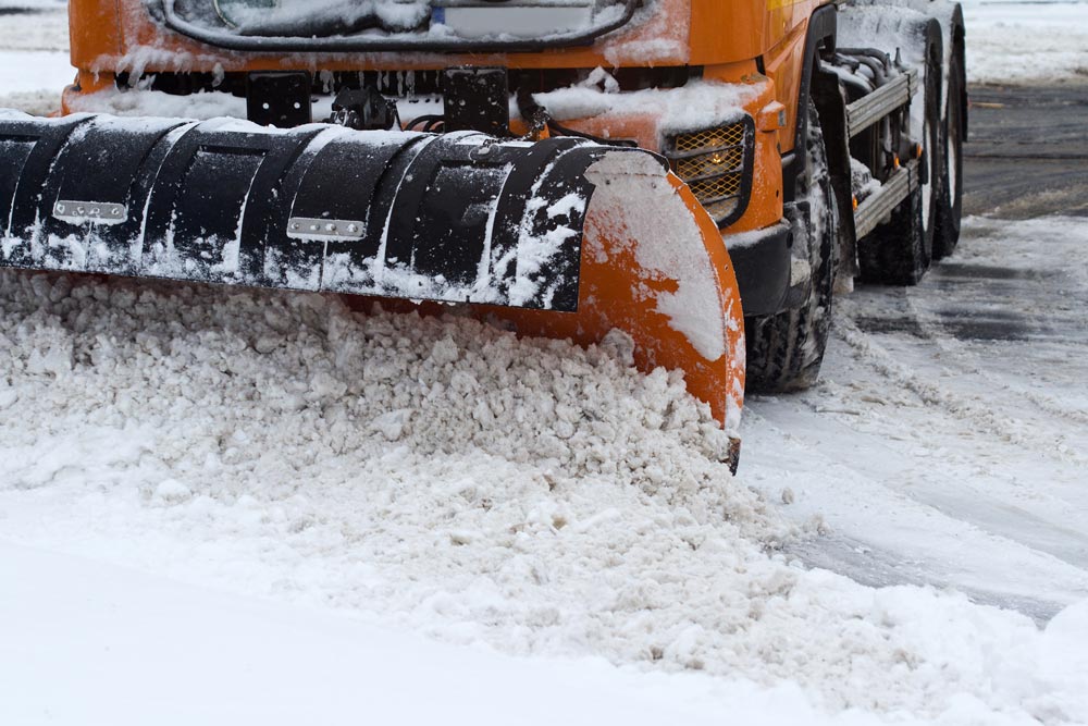 En snöplog arbetar aktivt med att röja snö på en stadsgata