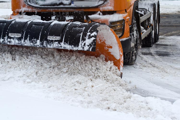En snöplog arbetar aktivt med att röja snö på en stadsgata